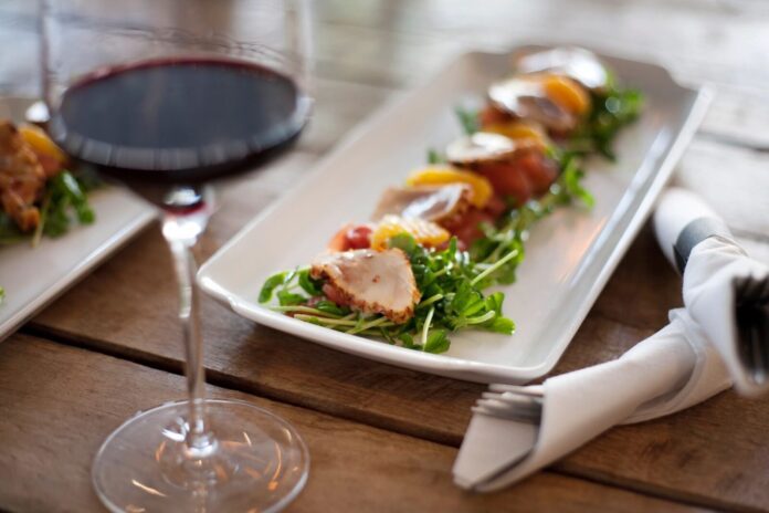 Wine and gourmet dish on wooden table. Wine and gourmet dish on wooden table.